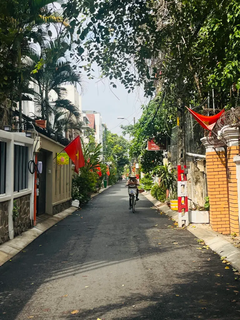 Cyclist on a leafy residential lane in Thảo Điền